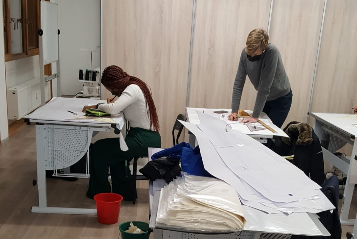 Élève en train de travailler sur un patron lors d'un cours de couture intensifde modélisme à l'école de mode.