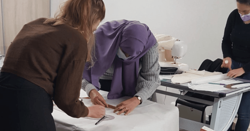 Élève en train de coudre un vêtement lors d'un cours de couture à l'école de mode.